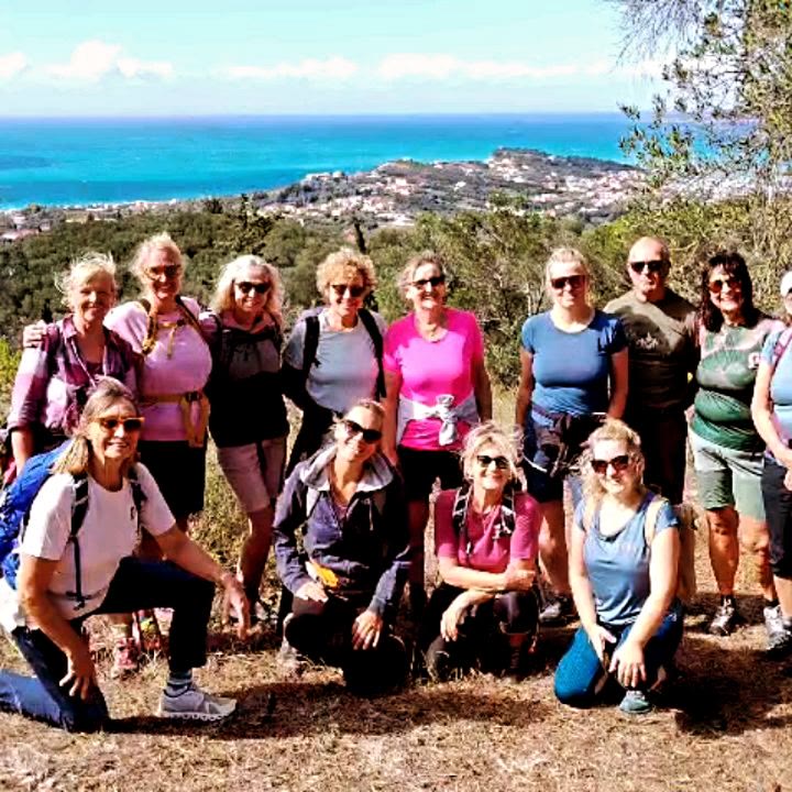Wandergruppe auf einer Anhöhe über einer Bucht
